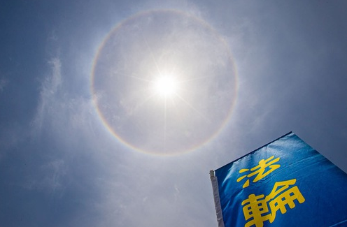 Image for article ​ไต้หวัน : พระอาทิตย์ทรงกลดปรากฏบนท้องฟ้าขณะที่ผู้ฝึกนับพันคนแปรอักษรเพื่อเฉลิมฉลองวันฝ่าหลุนต้าฝ่าโลก